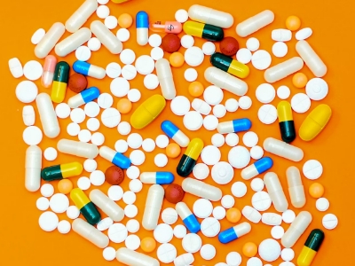 multi vitamins and medicine on a n orange table