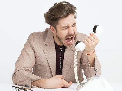 man in a suit yelling angrily on telephone