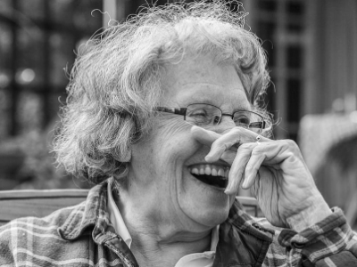 old woman in black and white hue laughing